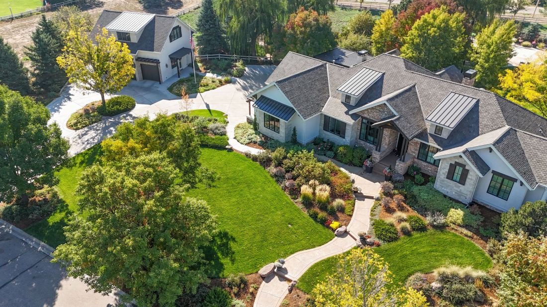 Vista aérea de una vivienda de Colorado con jardines, césped, árboles y parterres
